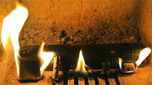 Tennbrikett med flammer i ovn